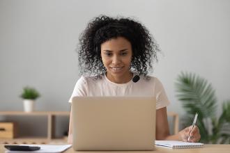 
		Frau blickt in die Kamera eines Laptops
	